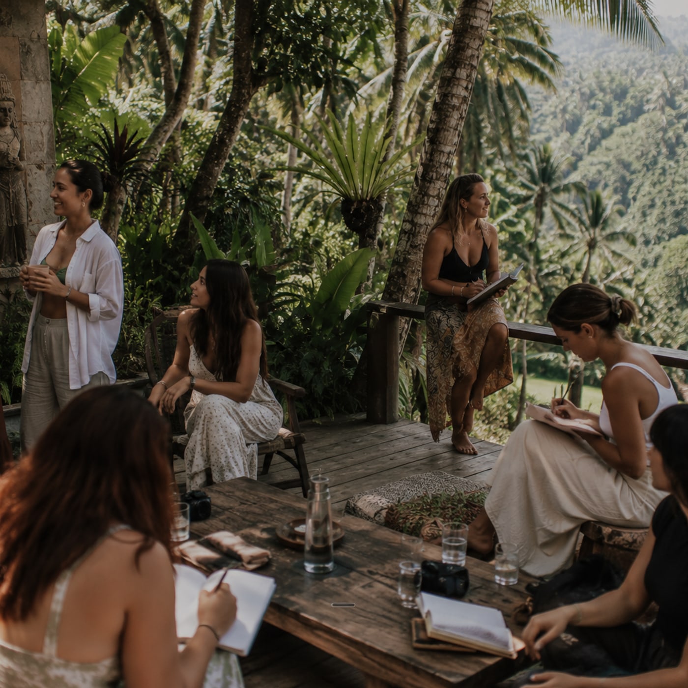 Women writing together on a jungle deck above the Bali rainforest, a Body & Soul retreat.